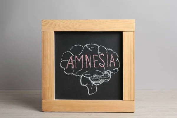 Pizarra Pequeña Con Cerebro Palabra Dibujada Amnesia Sobre Mesa Madera — Foto de Stock