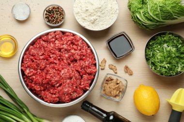 Tahta masanın üzerinde gyoza malzemelerinin olduğu düz bir kompozisyon vardı.