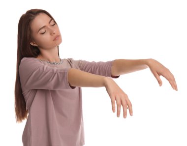 Beyaz arka planda uyurgezer halde pijama giyen genç bir kadın.