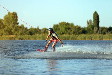 Genç çocuk nehirde wakeboard yapıyor. Aşırı su sporu