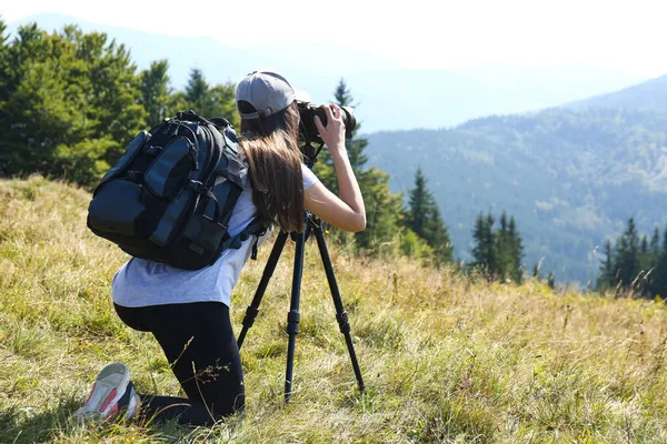 三脚で現代的なカメラで山の風景の写真を撮る女性屋外 — ストック写真