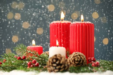 Karlar yanan mumlara, köknar dallarına ve çam kozalaklarına düşüyor bulanık festival ışıklarına, yazı için yere. Noel arifesi