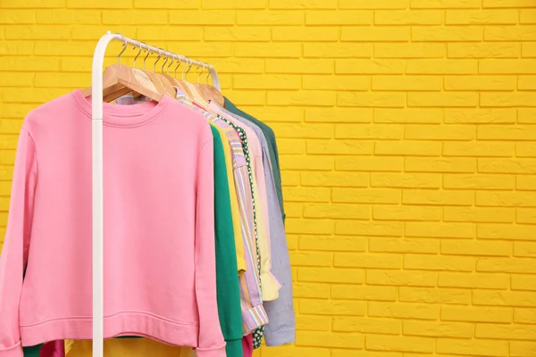 Bastidor Con Ropa Elegante Cerca Pared Ladrillo Amarillo Espacio Para — Foto de Stock