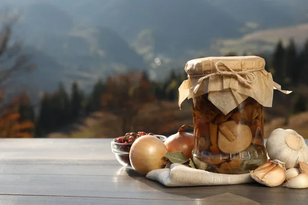 Dağ Manzarasına Karşı Ahşap Masa Üzerinde Turşulu Mantar Taze Malzemelerle — Stok fotoğraf