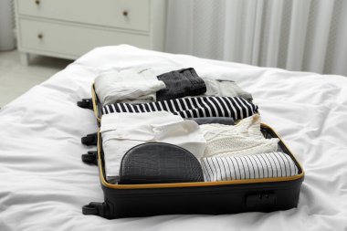 İçinde giysiler olan bavulu aç.