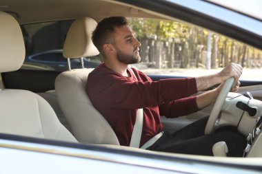 Modern arabada oturan yakışıklı genç sürücü.