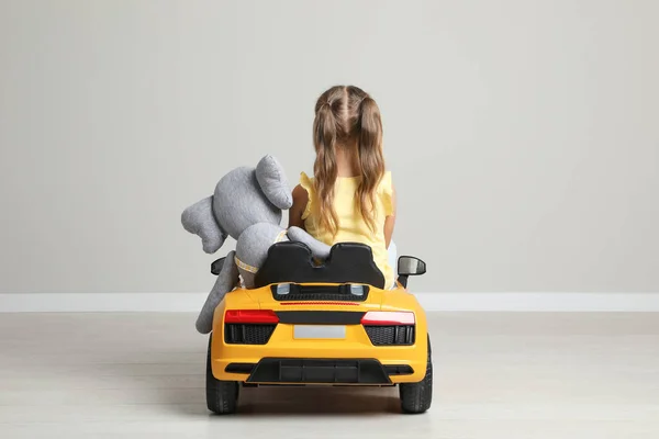 Cute Little Girl Toy Elephant Driving Children Car Grey Wall — Stock Photo, Image