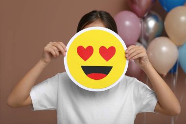 Süslü odada kalbi olan küçük bir kız emojisi.