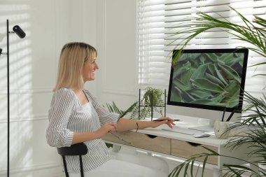 Kadın masadaki bilgisayarda çalışıyor. İç tasarım