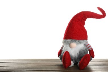 Beyaz arka plana karşı ahşap masadaki komik Noel cücesi. Metin için boşluk