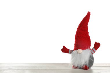 Beyaz arka plana karşı ahşap masadaki komik Noel cücesi. Metin için boşluk