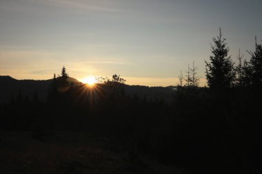 Güneşin güzel manzarası sabah dağların üzerinde parlıyor.