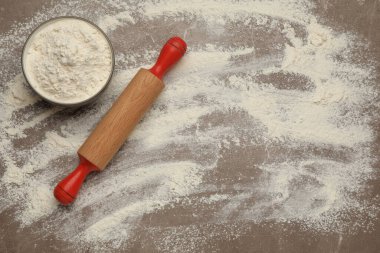 Ahşap merdane ve kase, gri zemin üzerinde un, düz yatıyordu. Metin için boşluk