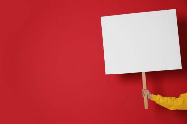 Kırmızı arka planda boş tabela tutan kadın, yakın plan. Metin için boşluk