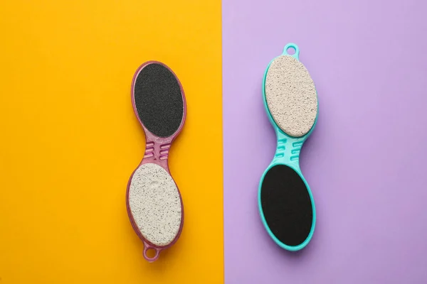 Pedicure tools with pumice stones and foot files on color background, flat lay