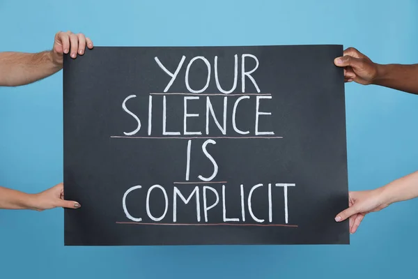 Mensen Houden Bord Met Zin Your Silence Complicit Lichtblauwe Achtergrond — Stockfoto