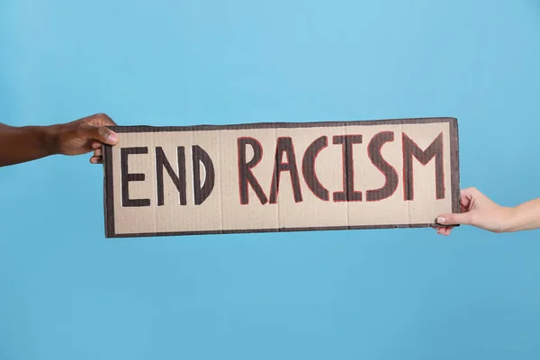 妇女与非裔美国男子手持标语 用短语结束浅蓝色背景的种族主义 — 图库照片