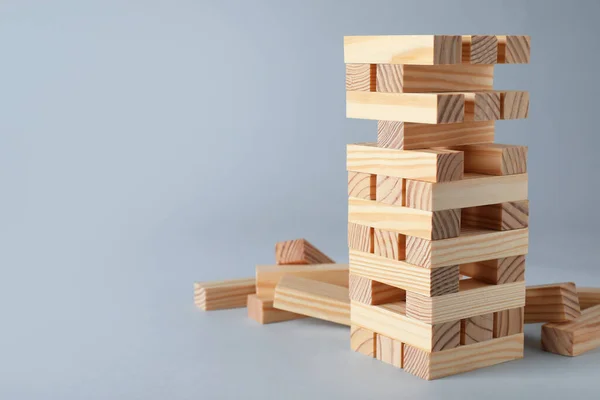 灰色の背景に木製のブロックで作られたJengaタワー テキストのためのスペース — ストック写真