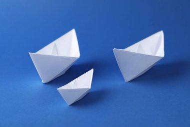 Mavi arka planda el yapımı kağıt tekneler. Origami sanatı