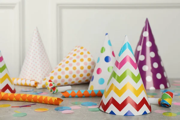 Colorful Party Hats Festive Items Grey Table White Wall Indoors — Stock Photo, Image