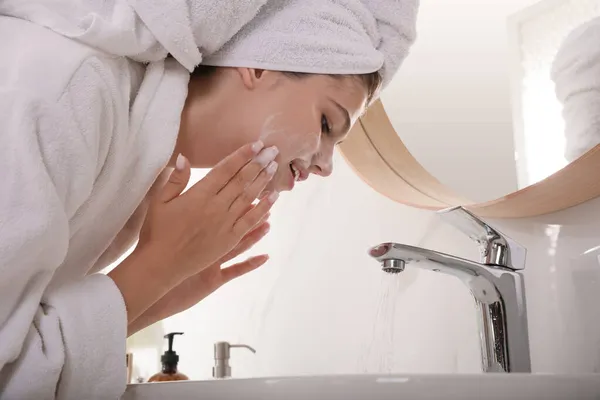 漂亮的少女在浴室里用洁白泡沫洗脸 护肤化妆品 — 图库照片