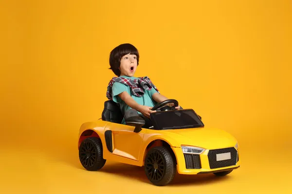배경에 장난감 자동차를 운전하는 어린아이 — 스톡 사진