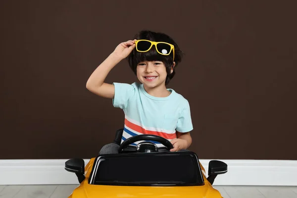 Aranyos Kisfiú Vezetés Gyerekek Elektromos Játék Autó Közelében Barna Fal — Stock Fotó
