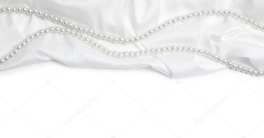 Beautiful pearls and delicate silk on white background