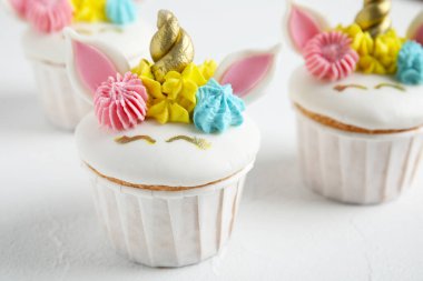 Beyaz masada şirin, tatlı, tek boynuzlu at kekleri, yakın plan.