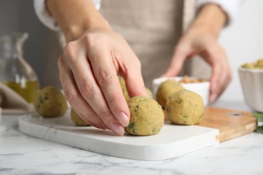 Beyaz mermer masada falafel topları yapan kadın, yakın plan.