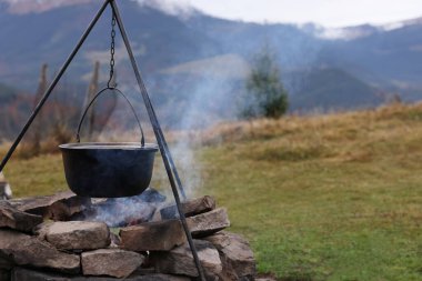 Dağlarda kamp ateşinde yemek pişirmek. Kamp sezonu