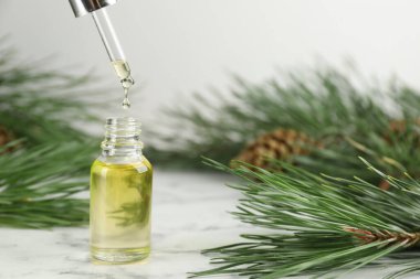 Beyaz mermer masada şişeye çam yağı damlatıyor. Metin için boşluk