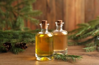 Ahşap masanın üzerinde çam yağı bulunan şişeler.