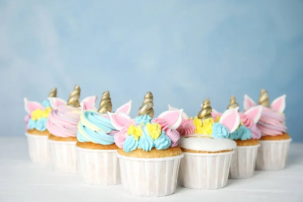 Πολλά Χαριτωμένα Γλυκά Cupcakes Μονόκερου Λευκό Ξύλινο Τραπέζι Φόντο Γαλάζιο — Φωτογραφία Αρχείου