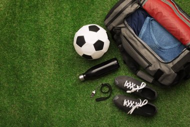 Spor çantası ve spor malzemeleri yeşil çimlerde, düz yerde. Metin için boşluk