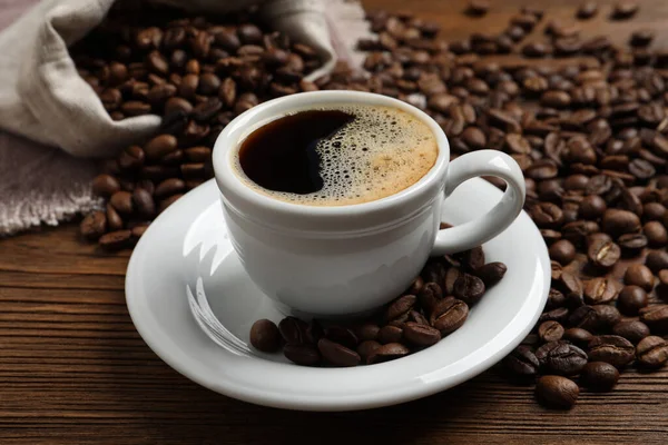 Tasse Aromatischer Heißer Kaffee Und Bohnen Auf Holztisch — Stockfoto