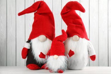 Masada beyaz ahşap arka planda sevimli noel cüceleri