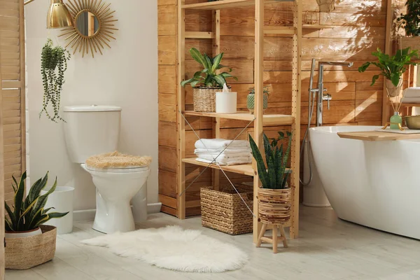 风格别致的浴室内部 白色浴缸和木制墙壁附近的绿色室内植物 设计的想法 — 图库照片