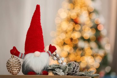 Süslü odadaki ahşap masada şirin bir noel cücesi.