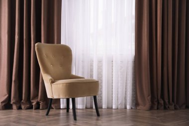 Pencerenin yanında rahat bir koltuk, mesaj için yer var. İç tasarım