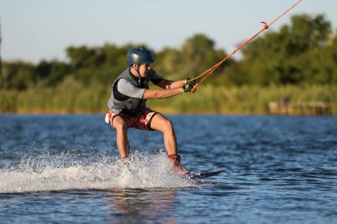 Genç çocuk nehirde wakeboard yapıyor. Aşırı su sporu