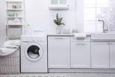 Çamaşır makinesi ve şık mobilyalarla dolu mutfak.