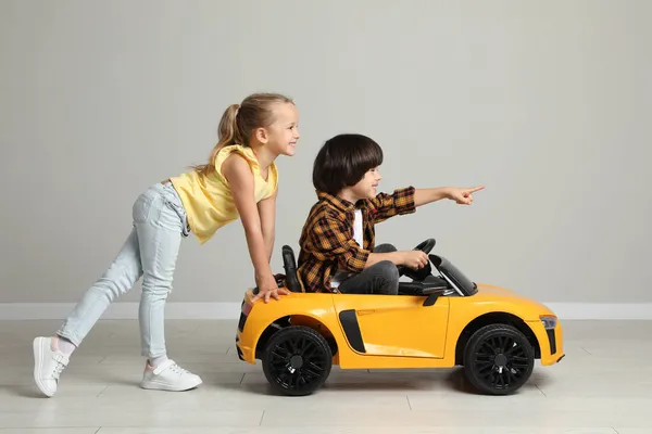 Cute Girl Pushing Children Electric Toy Car Little Boy Grey — Stock Photo, Image