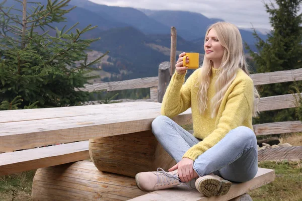 Mladá Žena Hrnkem Horkého Nápoje Dřevěné Lavičce Horách — Stock fotografie