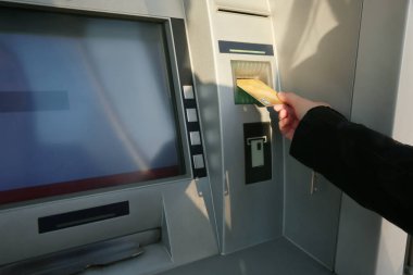 Para çekmek için para makinesini kullanan bir kadın. Açık hava, yakın çekim.