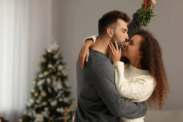 Happy Man Kissing His Girlfriend Mistletoe Bunch Room Decorated Christmas — ストック写真