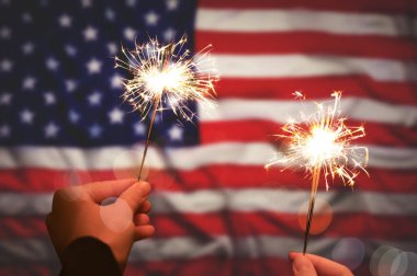 4 Temmuz - ABD 'nin Bağımsızlık Günü. Amerikan bayrağına karşı yanan maytaplar tutan kadınlar, yakın plan