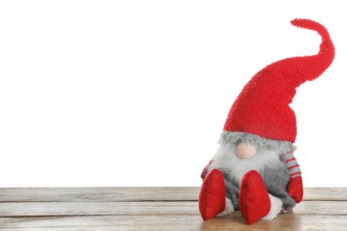 Beyaz arka plana karşı ahşap masadaki komik Noel cücesi. Metin için boşluk