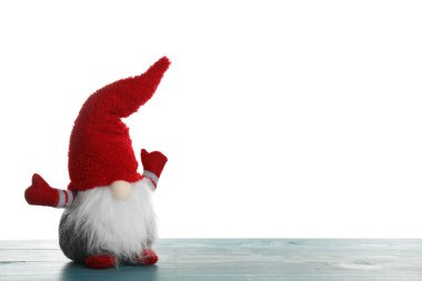 Turkuaz ahşap masada beyaz arka planda komik bir noel cücesi. Metin için boşluk