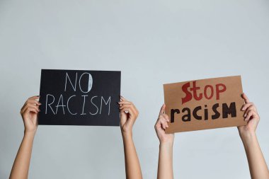 Gri arka planda tabela tutan kadınlar, yakın plan. Irkçılık kavramı